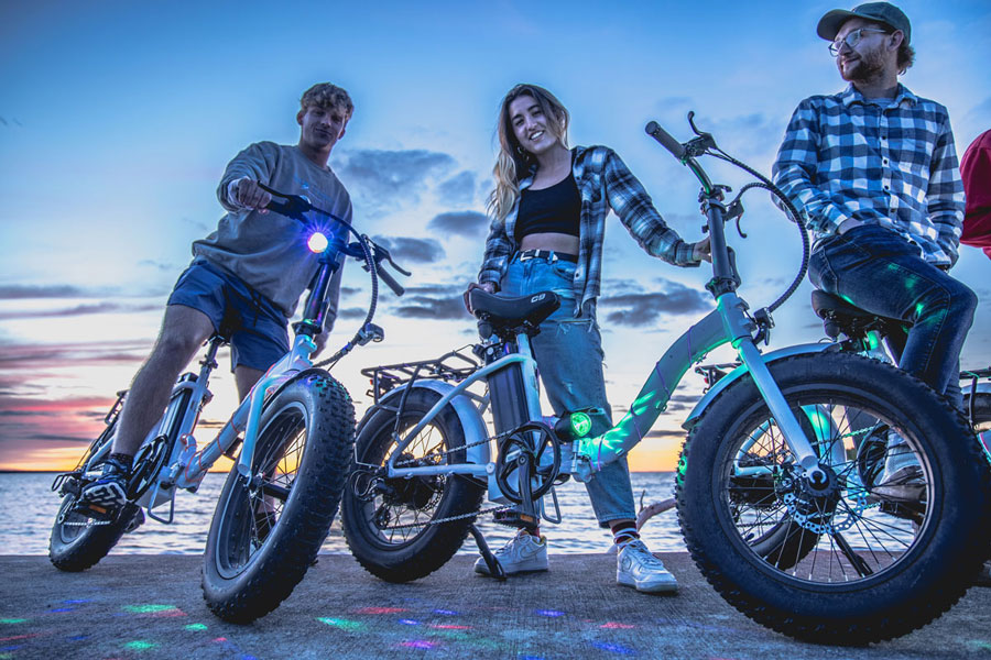 sunset-glow-roll-ebike-tourweb a group of people standing around a motorcycle
