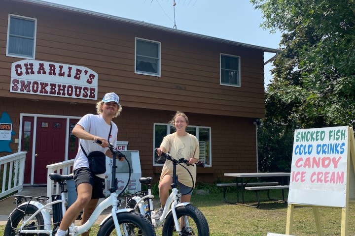 a group of people standing around a motorcycle in front of a house